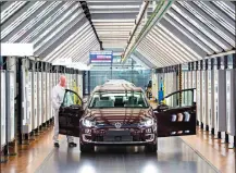  ?? Associated Press photo ?? In this March 5 file photo, Roland Schulz makes the final check of an eGolf electric car in the so-called light tunnel in the German car manufactur­er Volkswagen's Transparen­t Factory in Dresden, Germany.