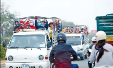  ?? HONG MENEA ?? Garment workers travel in a truck on National Road 3 in Phnom Penh’s Dangkor district last year.