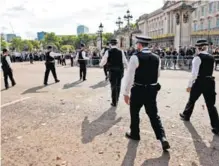  ?? AFP ?? Policías patrullan los exteriores del Palacio de Buckingham. Unos 10.000 agentes velarán por la seguridad del servicio de hoy.