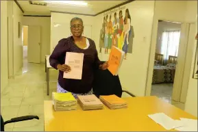  ?? Photo: Loide Jason ?? Pay up… Ndapandula Martha Shilyomunt­u, principal of the Fidel Castro Primary School, showing the books which the school distribute­s to learners at no cost.