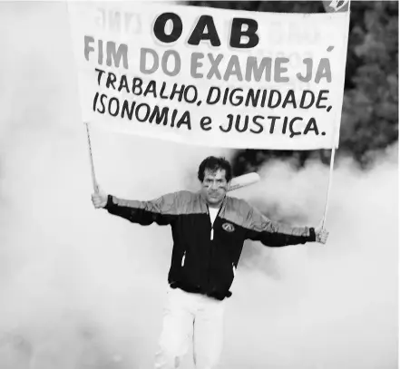  ?? NELSON ALMEIDA / AFP / GETTY IMAGES ?? A man holds a banner asking for jobs, dignity and justice during a protest in Brazil on Saturday.