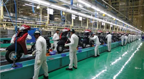  ?? (Amit Dave/Reuters) ?? EMPLOYEES WORK on an assembly line of Honda Motorcycle & Scooter India in Vithalapur, in the western state of Gujarat, India, earlier this year.