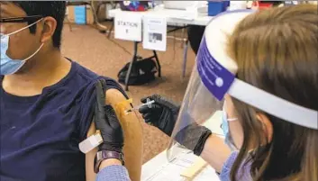  ?? Brittany Cruz-Fejeran San Diego Union-Tribune ?? A NATIONAL CITY resident gets a shot in 2021 at Martin Luther King Jr. Community Center in San Diego’s South County. The region is about 61% Latino, and nearly 40% speak a language other than English at home.