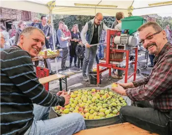  ?? RP-FOTO: JÜRGEN LAASER ?? In einer großen Zinkwanne wurden die Äpfel gewaschen und von Faulstelle­n befreit, dann wanderten sie in die Saftpresse. So verwandelt­e sich die mitgebrach­te Ernte von Besuchern an Haus Blumenthal in frischen Apfelsaft.