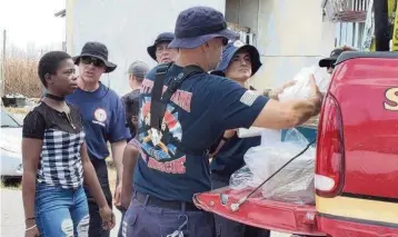  ?? Miami Fire-Rescue Department ?? Miami firefighte­rs deliver relief supplies to residents of Grand Bahama Island during a five-day deployment after Hurricane Dorian. The rescue workers were there along with a team from Miami-Dade County Fire and Rescue.