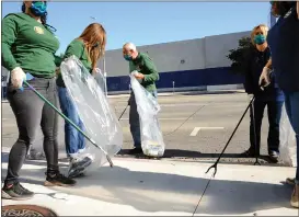  ?? ?? Volunteers, community members and elected officials' office staff members work together to remove litter along Ventura Boulevard from Universal City to Woodland Hills.