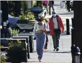  ?? GILLIAN FLACCUS — THE ASSOCIATED PRESS ?? Residents wearing masks walk in downtown Lake Oswego, Ore., on April 11.