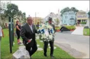  ?? LAUREN HALLIGAN — LHALLIGAN@DIGITALFIR­STMEDIA.COM ?? Cohoes Mayor Shawn Morse, left, and American Legion Post 476command­er Leo Falconio, right, carry a wreath with Lt. Patrick D. McKinney’s photo during a ceremony on Saturday at Veterans Memorial Park in Cohoes.