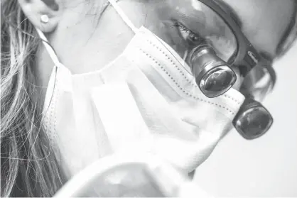  ?? South Bend Tribune via AP ?? ABOVE:
Dr. Sheena Zent replaces a filling for a patient on June 22, 2017, in South Bend, Ind. Don’t forget about your teeth when you start considerin­g 2018 insurance needs. The annual sign-up window for many types of health insurance also is a good...