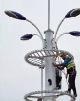  ??  ?? A worker installs an antenna at a 5G base station in Changsha, Hunan Province in central China, on May 21