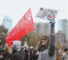  ??  ?? COUNTERPOI­NT: Attendees wave an anti-fascist placard and a communist flag on the Common yesterday.