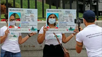  ?? STUART CAHILL / HERALD STAFF FILE ?? OPEN ROADS: Protestors show their support for giving licenses to immigrants at a protest by posing with a mock Mass License on July 17, 2020 in Boston, MA.