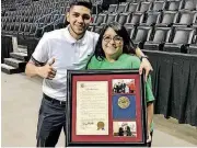  ?? [PHOTO BY RYAN SHARP, THE OKLAHOMAN] ?? Boxer Alex Saucedo poses with his Heronville Elementary School teacher, Tiffany Olvera, who is holding a framed proclamati­on from the city of Oklahoma City.