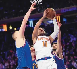  ?? MARY ALTAFFER/ASSOCIATED PRESS ?? New York Knicks guard Jalen Brunson (11) drives to the basket between the Denver Nuggets’ Nikola Jokic, left, and Jamal Murray during Saturday’s game in New York.