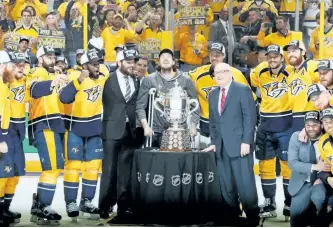  ?? FREDERICK BREEDON/GETTY IMAGES ?? Injured forward Ryan Johansen (centre) of the Nashville Predators celebrates with the Clarence S. Campbell Bowl and teammates after they defeated the Anaheim Ducks 6-3 in Game 6 of the Western Conference Final at Bridgeston­e Arena in Nashville, Tenn.,...