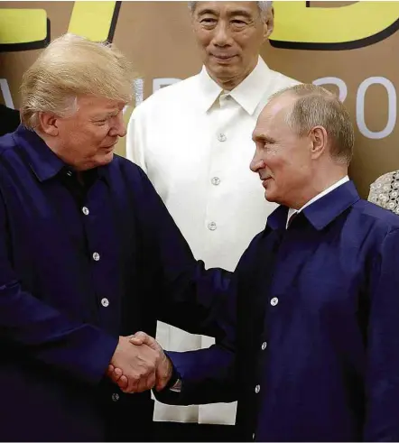  ?? Mikhail Klimentyev/Sputnik/Kremlin/Reuters ?? Trump cumpriment­a Putin ao tirar foto no Vietnã; desde 1994, vestuário típico do país-sede é usado no retrato oficial