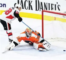  ?? (Reuters) ?? OTTAWA SENATORS forward Mike Hoffman (left) watches the puck slide past Philadelph­ia Flyers netminder Michal Neuvirth for game-winning shootout goal in the Senators’ 4-3 road victory over the Flyers on Saturday night.