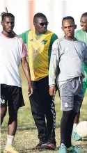  ?? FILE ?? Coach Omar Edwards (second left) works with players of the Tivoli Gardens football club during a training session at Edward Seaga Sports Complex last week.