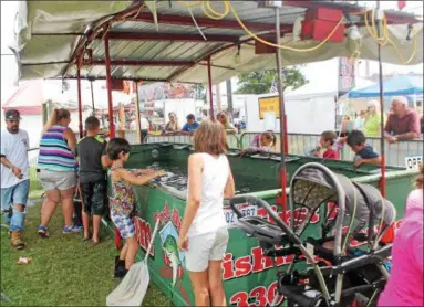  ?? KRISTI GARABRANDT — THE NEWS-HERALD ?? First Bite Fish Tanks, a new attraction to the Lake County Fair, teaches kids the basics of fishing and has a steady line of kids waiting to try it July 26.