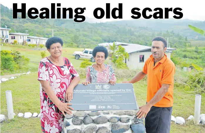  ?? Picture: BALJEET SINGH ?? Litiana Tiqe, left, with Losana Nai and Simione Deruru beside the memorial plaque that honours the memory of a family of four that were killed in a massive landslide at Tukuraki Village in Ba.