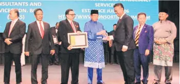  ??  ?? Janang (third right) receives the award from Chief Minister Datuk Patinggi Abang Johari Tun Openg at BCCK. — Photo courtesy of KBCS