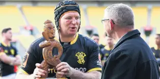  ??  ?? Coveted trophy . . . Wellington captain Thomas Waldrom accepts the Mike Gibson Memorial Trophy from Guy Gibson after beating Otago in Wellington in 2018; Gibson at an Otago training at Bathgate Park in the mid1980s.