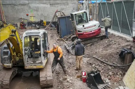  ?? Drew Angerer/Getty Images ?? Constructi­on workers are busy Friday at a job site in New York City’s Lower Manhattan.