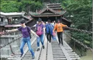  ?? WANG HUABIN / FOR CHINA DAILY ?? Tourists negotiate the Luding Bridge across the Dadu River in Southwest China’s Sichuan province. Associated with the Long March, the site is popular on the red tourism circuit.