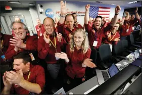  ?? AL SEIB / LOS ANGELES TIMES VIA AP (ABOVE); NASAVIAAP(ATLEFT) ?? Engineers celebrate as the Insight lander touches down on Mars in the mission support area of the space flight operation facility at NASA’S Jet Propulsion Laboratory on Nov. 26 in Pasadena, Calif. At left is an image transmitte­d from Mars by the Insight lander.