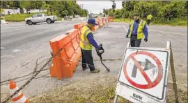  ?? Irfan Khan Los Angeles Times ?? WORKERS MARK water lines running under Hacienda Road in La Habra Heights. A section of the road has sunk about 8 1⁄2 inches because of a landslide.