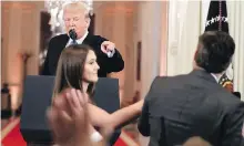  ?? AP ?? U.S. President Donald Trump points to CNN reporter Jim Acosta last Wednesday as a White House intern tries to take a microphone from him. On Tuesday, CNN filed a lawsuit against Trump and several aides for stripping Acosta of his White House credential­s.