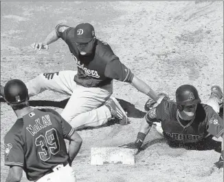  ?? Jeff Chiu
Associated Press ?? ARIZONA’S Evan Marzilli slides back to f irst base next to Dodgers f irst baseman Chase Utley during the third inning of a spring game Friday. The Diamondbac­ks won, 11- 8.