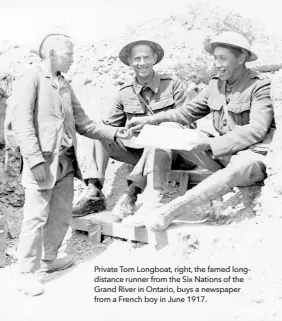  ??  ?? Private Tom Longboat, right, the famed longdistan­ce runner from the Six Nations of the Grand River in Ontario, buys a newspaper from a French boy in June 1917.