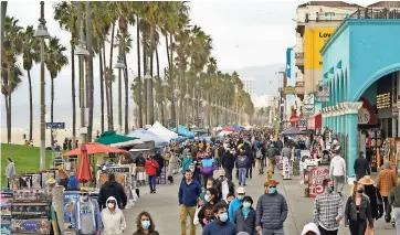  ??  ?? PERSONAS CAMINAN por el malecón de Venice Beach en Los Ángeles