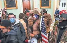  ?? SAUL LOEB/AFP VIA GETTY IMAGES ?? Supporters of former President Donald Trump, including Jake Angeli, a QAnon supporter, enter the Capitol.