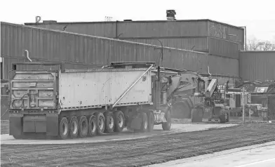  ?? JUNFU HAN/DETROIT FREE PRESS ?? A truck drives into the lot of Pro V Enterprise­s on Wyoming Avenue in Dearborn on Thursday. The city’s lawsuit against Pro V Enterprise­s asks a Wayne County judge to declare the pollution a public nuisance and order the company to reduce the dust or shut down until it can do so.