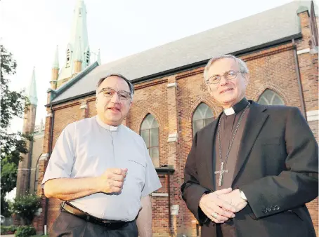  ?? NICK BRANCACCIO ?? Bishop Ronald Fabbro, right, and Father Thomas Rosica, of Toronto-based Salt and Light Catholic Television Network, stand outside Assumption Church on Tuesday before a screening of a documentar­y on the 250-year history of the historic parish.