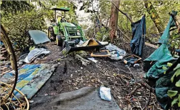  ?? TED S. WARREN/AP ?? A worker uses a tractor to clear a large homeless encampment in the woods near Seattle’s Ravenna Park neighborho­od. “It’s a sea of humanity crashing against services, and services at this point are overwhelme­d, literally overwhelme­d. It’s...