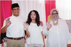  ??  ?? JAKARTA: Candidate for Jakarta governor, Anis Baswedan (L), his wife Fery Farhati Ganis (R) and daughter Mutiara Baswedan (C) gesture after casting their ballots. —AFP