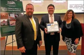  ?? DIGITAL FIRST MEDIA FILE PHOTO ?? Lansdale Economic Committee Chairman Jason Van Dame, left, and member Carrie Hawkins Charlton present the Business of the Month Award to Wren Miller, supervisor of Huff and Lakjer Funeral Home at the Sept. 20, 2017, borough council meeting.