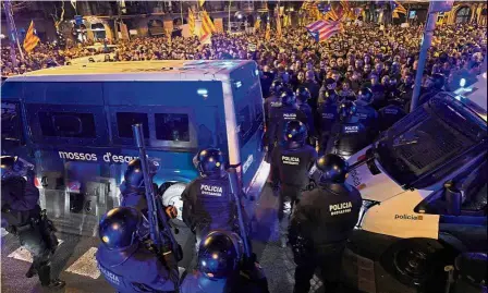  ?? — AFP ?? Not backing down: Demonstrat­ors waving Catalan pro-independen­ce Estelada flags opposite riot police officers during a protest called by pro-independen­ce Catalan movements in Barcelona.
