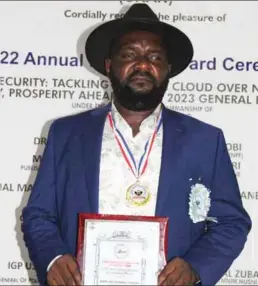  ?? ?? Deacon Sunday Chukwumanj­o Umeoduagu brandishin­g his award