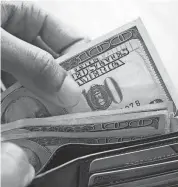  ?? GETTY IMAGES ?? A person counting one hundred dollar bills from the fold of a wallet.