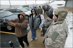  ?? GENE J. PUSKAR — THE ASSOCIATED PRESS ?? Anthony Kiley, left, of Columbus, takes a selfie with Sterling Shrout, second from left, of Dayton, as they wait in line on the first day of sales at Cresco Labs CY+ dispensary as part of Ohio’s Medical Marijuana program in Wintersvil­le, Wednesday.