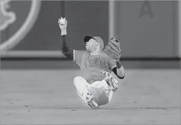  ?? Sean M. Haffey Getty Images ?? ACROBATIC ANGELS SHORTSTOP Andrelton Simmons winds up on his backside as he chases down a f ly ball off the bat of the Cleveland Indians’ Jay Bruce in the first inning Wednesday night.