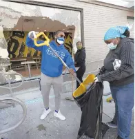  ?? JESSICA GRIFFIN/AP ?? Community members clean up broken glass Monday at a McDonald’s in West Philadelph­ia following protests against police brutality Sunday that turned violent.