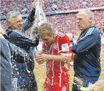  ?? FOTO: IMAGO ?? Carlo Ancelotti (li.), eigentlich Weintrinke­r, begießt Philipp Lahm, Hermann Gerland gefällt das.