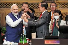  ?? — AFP ?? Passing the baton: Jokowi handing Modi a gavel during the handover ceremony at the G20 Summit in Nusa Dua on the Indonesian resort island of Bali.