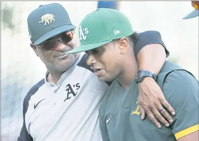  ?? DUANTE BURLESON — THE ASSOCIATED PRESS ?? A’s assistant hitting coach Eric Martins puts his arm around Khris Davis as they leave the field following batting practice.