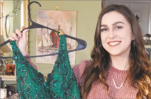  ?? Jill Dion / Hearst Connecticu­t Media ?? Caitlyn Zawadski holds up the gown she will wear in the Milford St. Patrick’s Day Parade on March 9, when she will serve as Miss Emerald Isle.